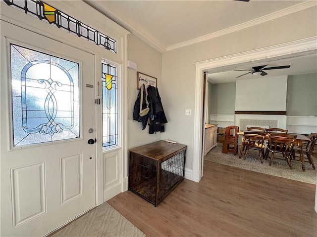 entrance foyer featuring crown molding, ceiling fan, and wood finished floors