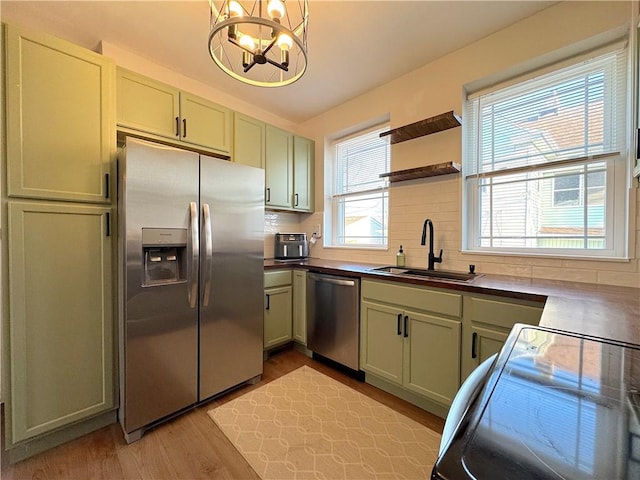 kitchen featuring open shelves, a sink, decorative backsplash, stainless steel appliances, and light wood-style floors