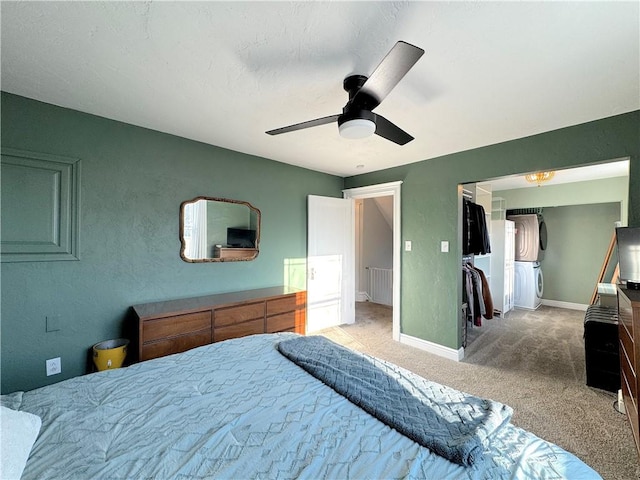 carpeted bedroom with ceiling fan, washer / clothes dryer, baseboards, and a textured wall