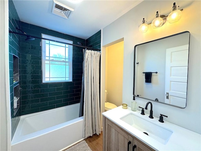 bathroom with visible vents, vanity, and shower / bath combo