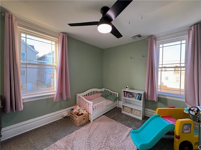 carpeted bedroom with visible vents, ceiling fan, and baseboards