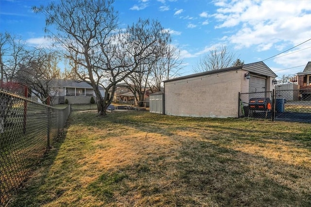 view of yard featuring a garage, an outdoor structure, and fence