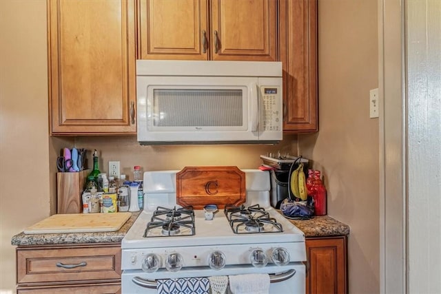 kitchen featuring white appliances and brown cabinetry