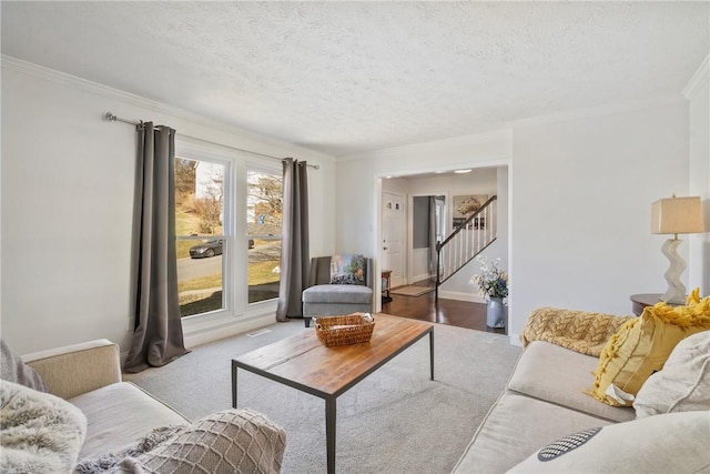 living room with stairs, crown molding, carpet flooring, and a textured ceiling