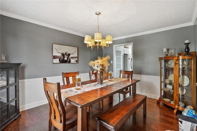 dining area featuring crown molding, wood finished floors, baseboards, and a chandelier