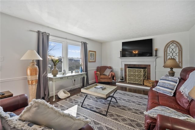 living room featuring baseboards, wood finished floors, and a fireplace