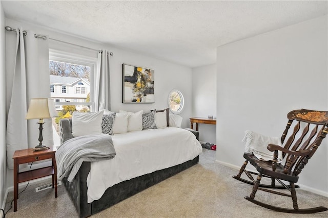 carpeted bedroom featuring visible vents, baseboards, and a textured ceiling