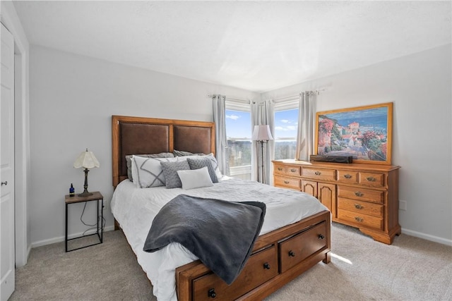 bedroom featuring baseboards and light carpet