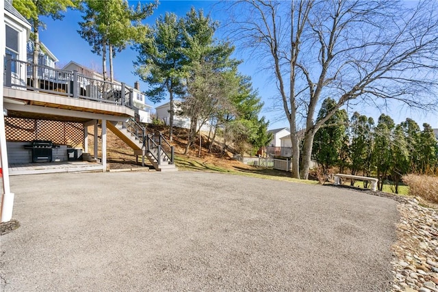 exterior space featuring stairway, a wooden deck, and aphalt driveway