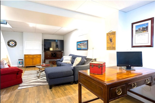 living room with light wood-style flooring and a paneled ceiling