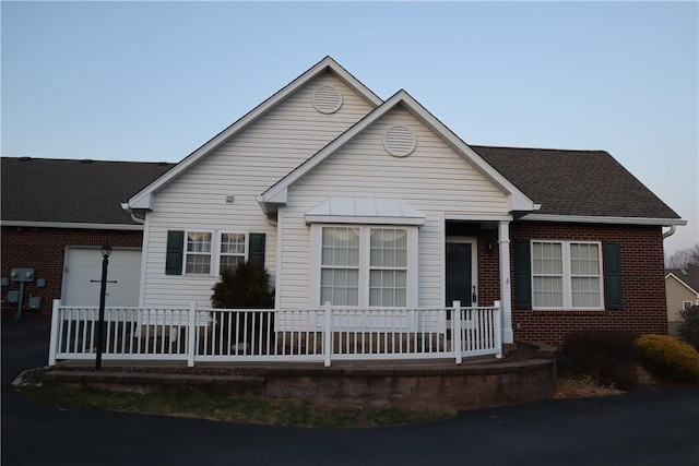 view of front facade featuring brick siding and covered porch