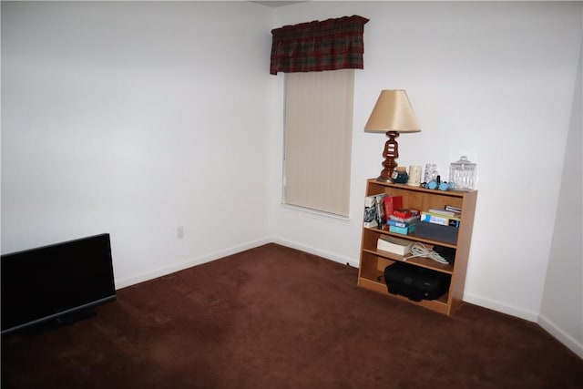 empty room featuring baseboards and carpet