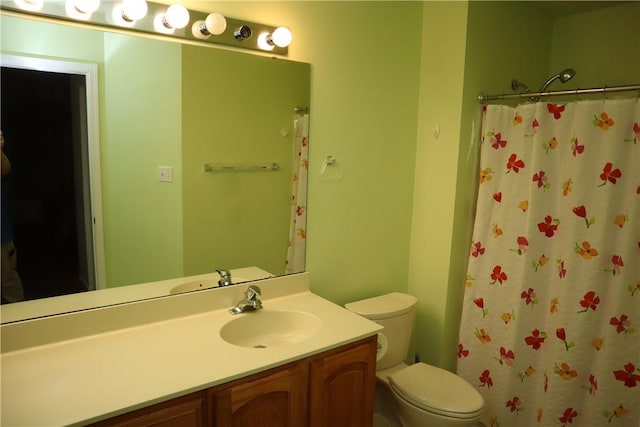 bathroom with curtained shower, toilet, and vanity