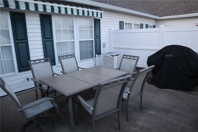 view of patio featuring outdoor dining space, fence, and grilling area