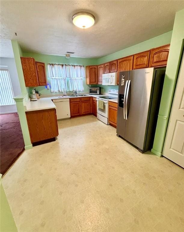 6233 Oyster Bay Ct, South Fayette, PA 15017 - kitchen with white appliances, brown cabinetry, a textured ceiling, light countertops, and light flooring
