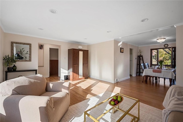 living room featuring recessed lighting, baseboards, and light wood-type flooring