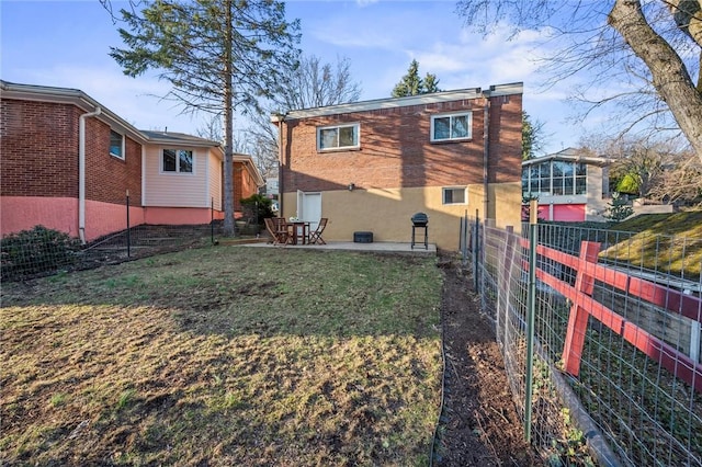 back of property featuring fence, a lawn, and a patio area