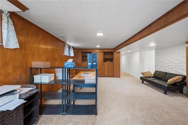 carpeted office space featuring wood walls