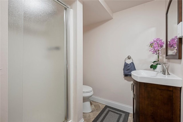 full bath featuring a shower stall, toilet, vanity, and baseboards