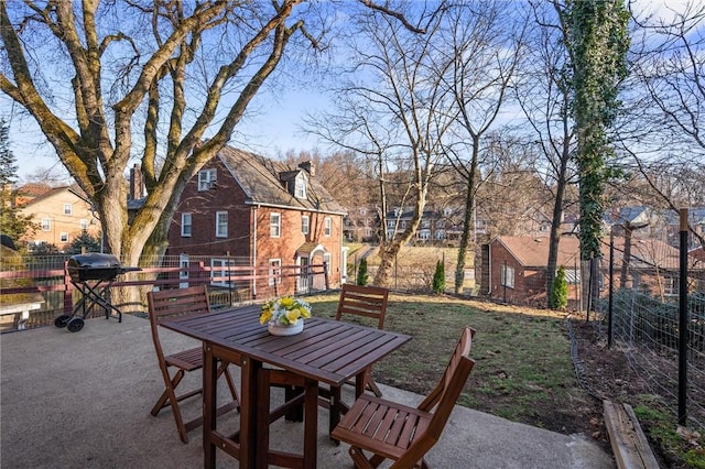 view of patio / terrace featuring outdoor dining space, fence, a residential view, and grilling area