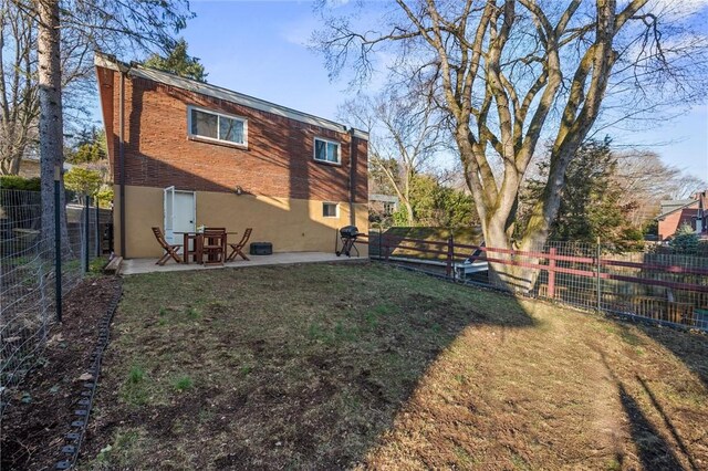 rear view of house with a yard, a patio area, a fenced backyard, and stucco siding