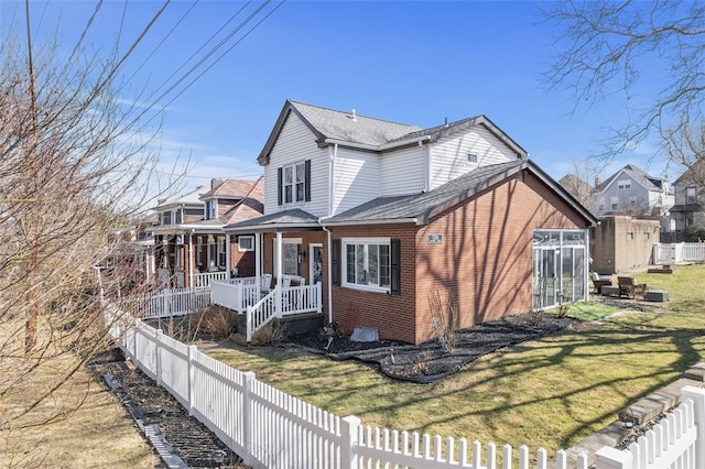 view of home's exterior with brick siding, fence private yard, and a yard