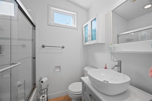 bathroom featuring a shower with shower door, baseboards, toilet, and vanity