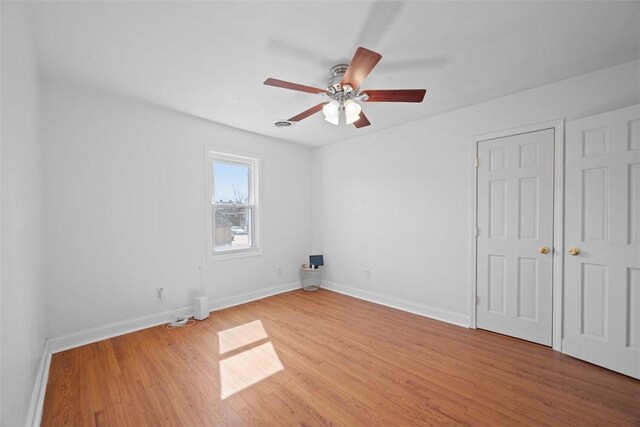 unfurnished bedroom featuring light wood-style flooring, baseboards, and ceiling fan