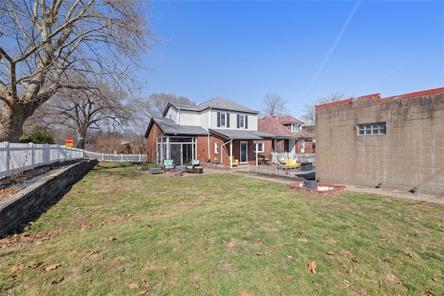 back of property featuring a yard, a patio, brick siding, and a fenced backyard