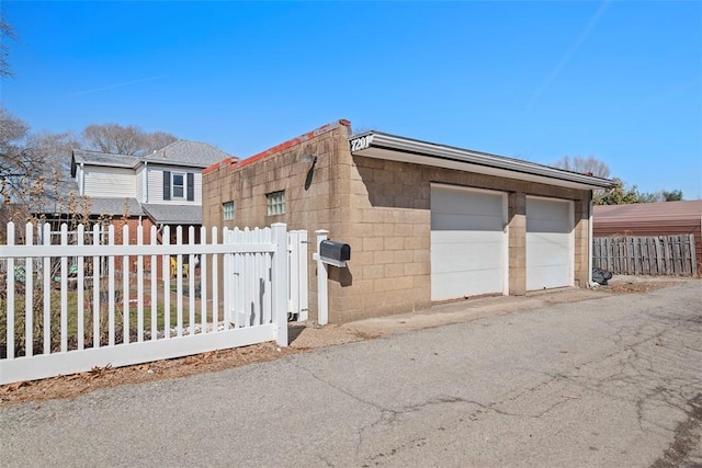 exterior space with a fenced front yard and a detached garage