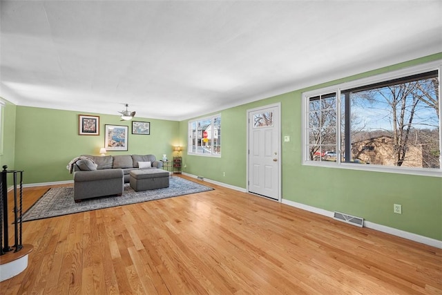 living room with visible vents, baseboards, and wood finished floors