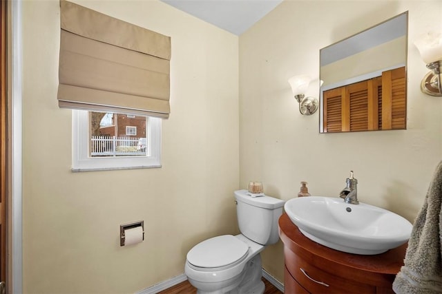 bathroom with baseboards, toilet, and vanity