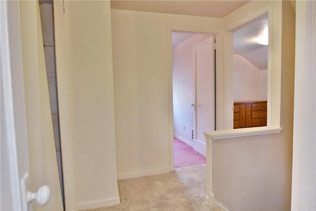 hallway with baseboards and carpet