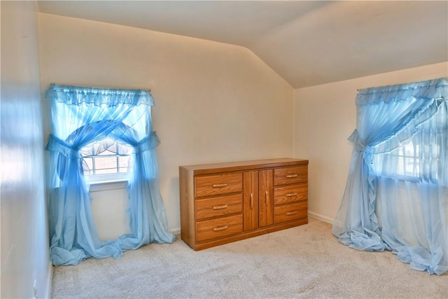 bedroom with vaulted ceiling and light carpet