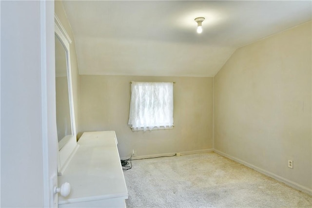 interior space with baseboards, lofted ceiling, and carpet floors