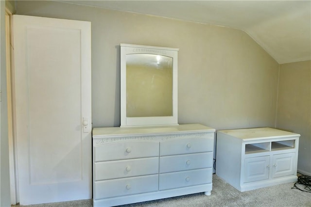 unfurnished bedroom featuring light carpet and vaulted ceiling