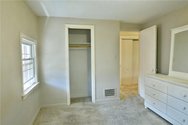 unfurnished bedroom with a closet, visible vents, baseboards, and carpet