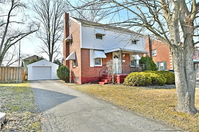 view of front of property featuring an outbuilding, fence, a chimney, a detached garage, and brick siding