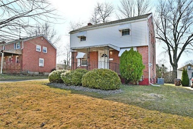 view of front of house featuring brick siding, a chimney, central AC, and a front lawn