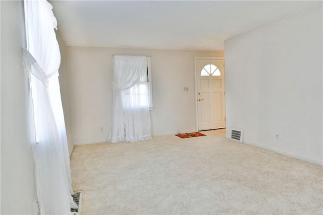 carpeted foyer with visible vents and baseboards