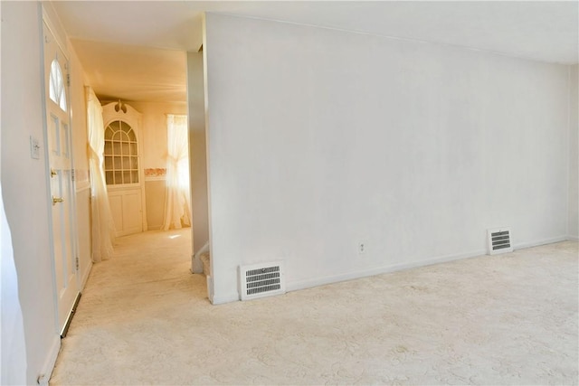 unfurnished room featuring visible vents and light colored carpet