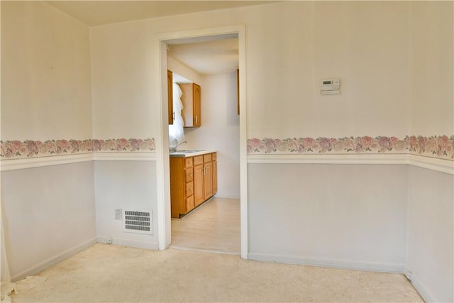 interior space with a sink, visible vents, and light carpet