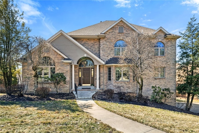 view of front facade with a front lawn and brick siding