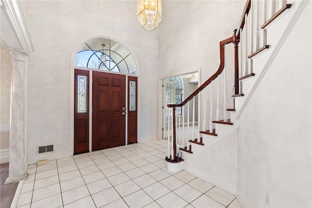 foyer featuring visible vents, stairs, baseboards, and decorative columns