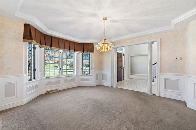 unfurnished dining area featuring visible vents, carpet floors, wainscoting, and wallpapered walls