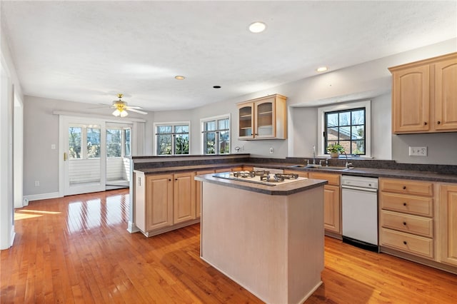 kitchen featuring light brown cabinetry, light wood-style flooring, white gas stovetop, and a healthy amount of sunlight