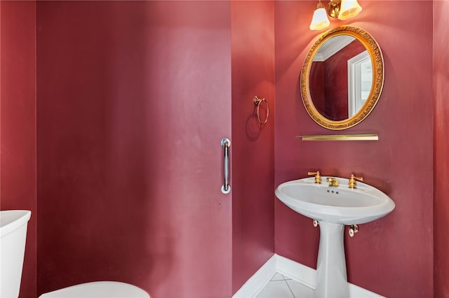 bathroom featuring baseboards, toilet, and tile patterned flooring