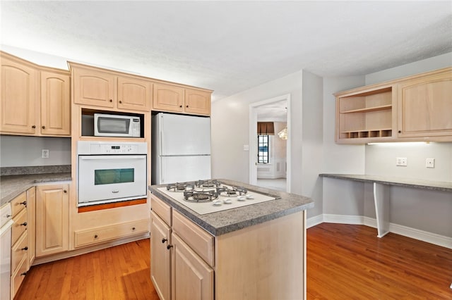 kitchen with white appliances, light wood finished floors, a kitchen island, open shelves, and light brown cabinetry