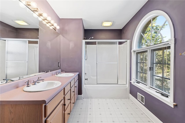 bathroom with a sink, baseboards, double vanity, and tile patterned floors