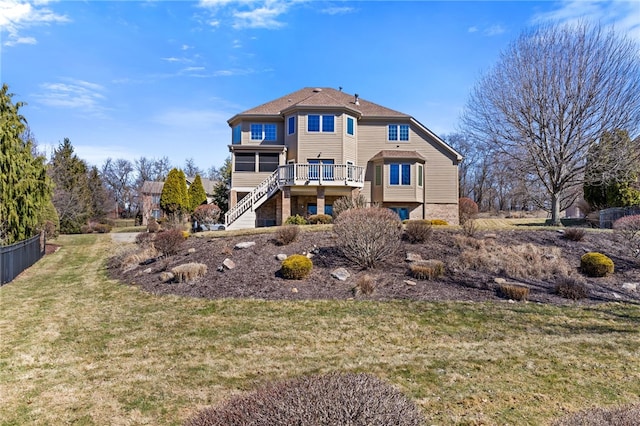 back of house with stairway, a lawn, and a wooden deck